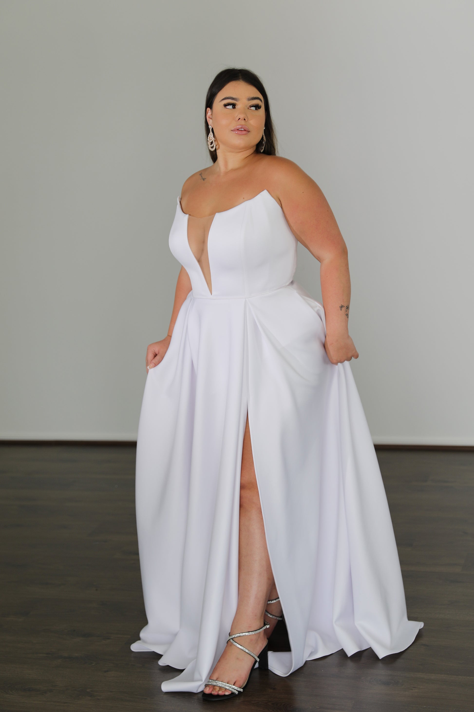 model posing in white formal dress with leg slit and v-neck